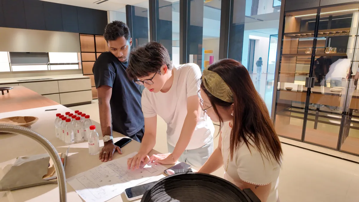 Three people discuss material options at a display.