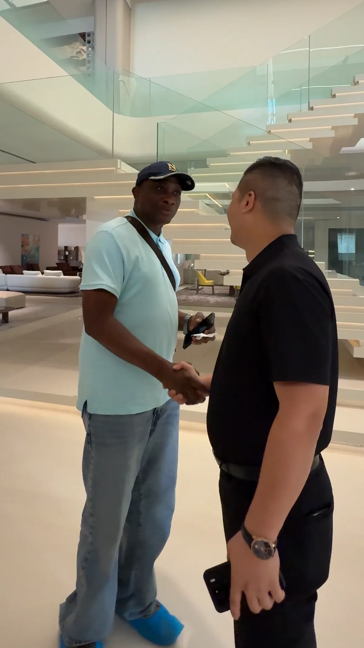 Two people shake hands during a visit.