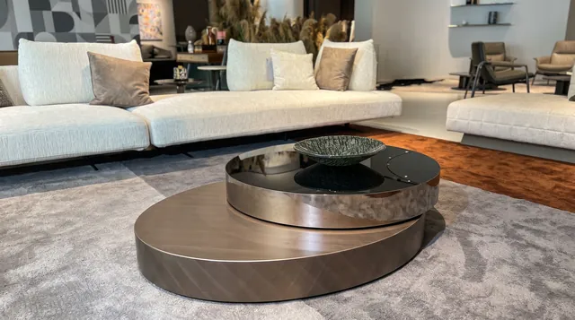 Two overlapping round low table volumes with contrasting darker and lighter surfaces; the nearer circular base is fully readable.