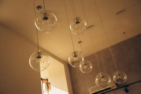 A group of clear spherical pendant lights suspended in a warm interior.