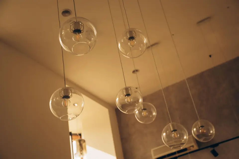 A group of clear spherical pendant lights suspended in a warm interior.