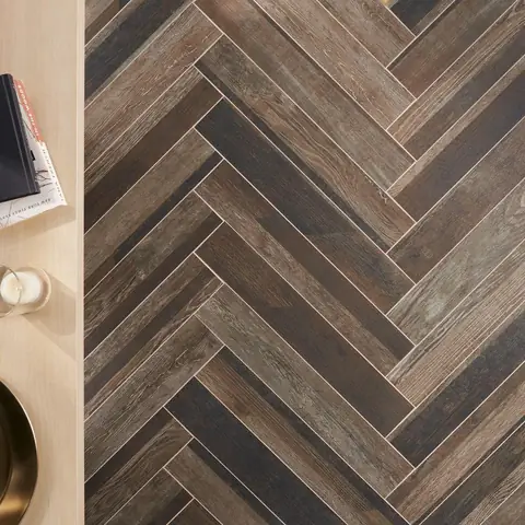 Close view of a dark herringbone floor pattern with varied brown tones.
