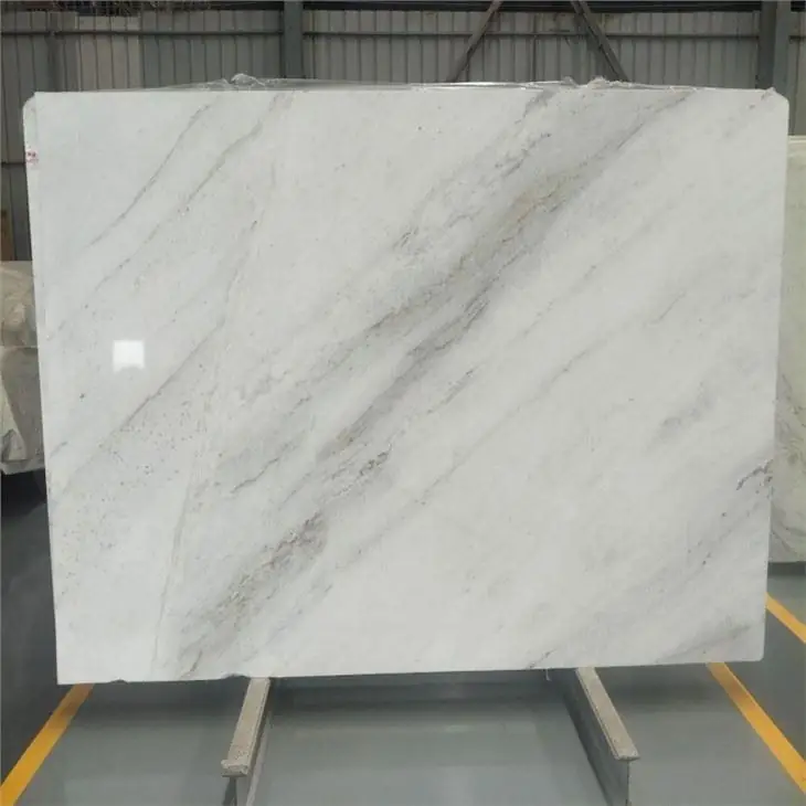 An upright pale stone slab with subtle grey veining photographed in a material storage setting.
