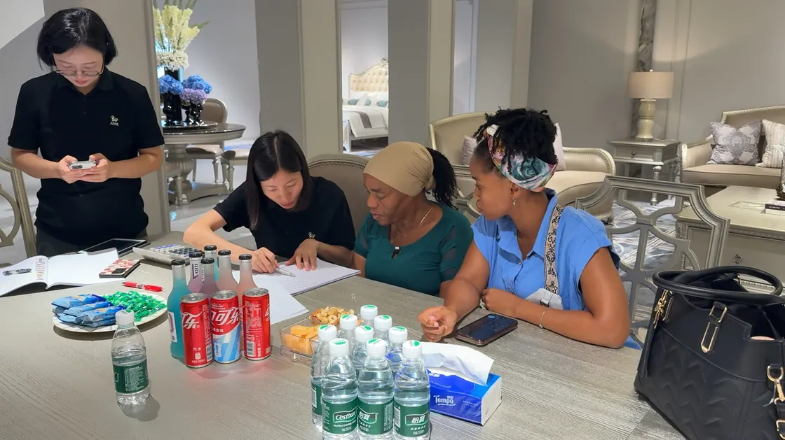 People sit together at a table while one person points to a page.
